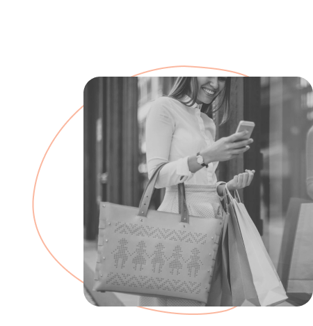 woman holding many shopping bags and smiling at her phone